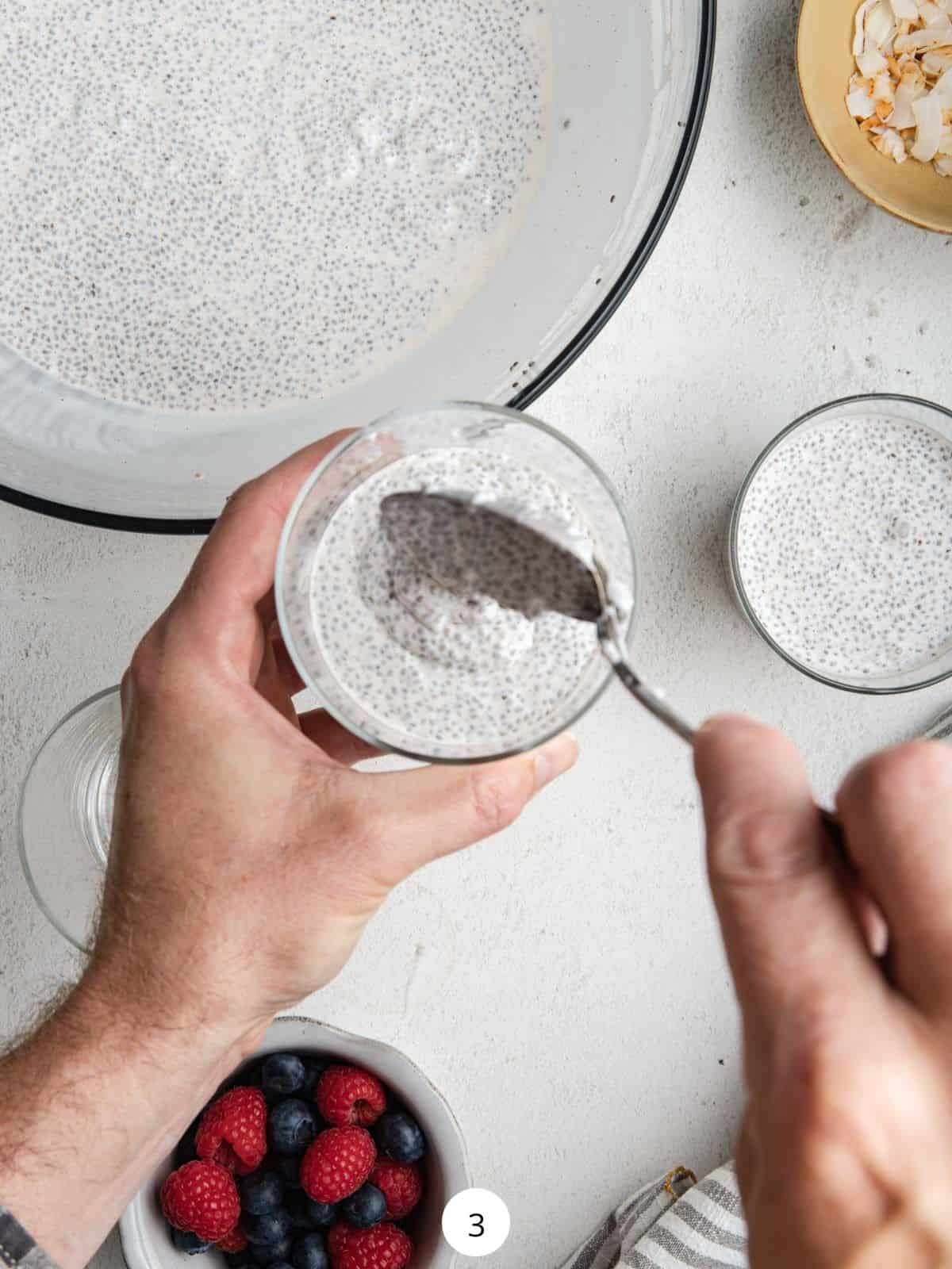 Spooning the coconut chia pudding into glass jars.