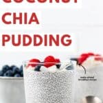Chia pudding in a glass jar topped with fresh berries and a spoon placed right next to it.