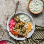 A pasta bowl with cous-cous, white rice, pickled red onions, and turkey feta meatballs.