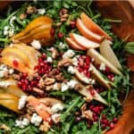 Arugula Pear Salad inside of a large wooden bowl.