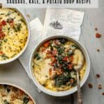 A round soup bowl filled with a sausage, potato, and kale soup with a soup spoon.