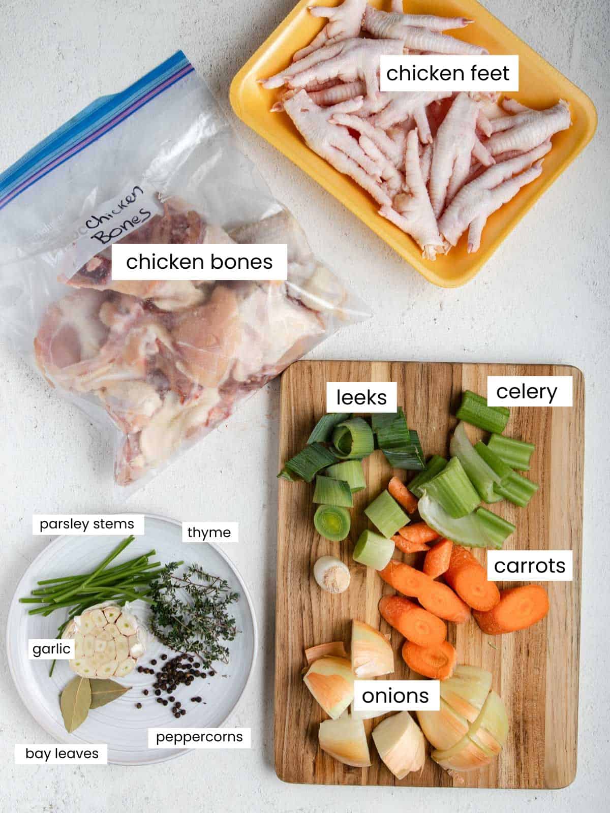 Chicken feet, chicken bones, leeks, celery, carrots, onions, parsley, thyme, garlic, peppercorns, and bay leaves.