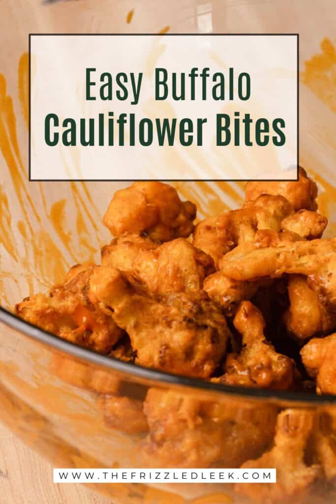 Buffalo sauce coated cauliflower in a large glass bowl.