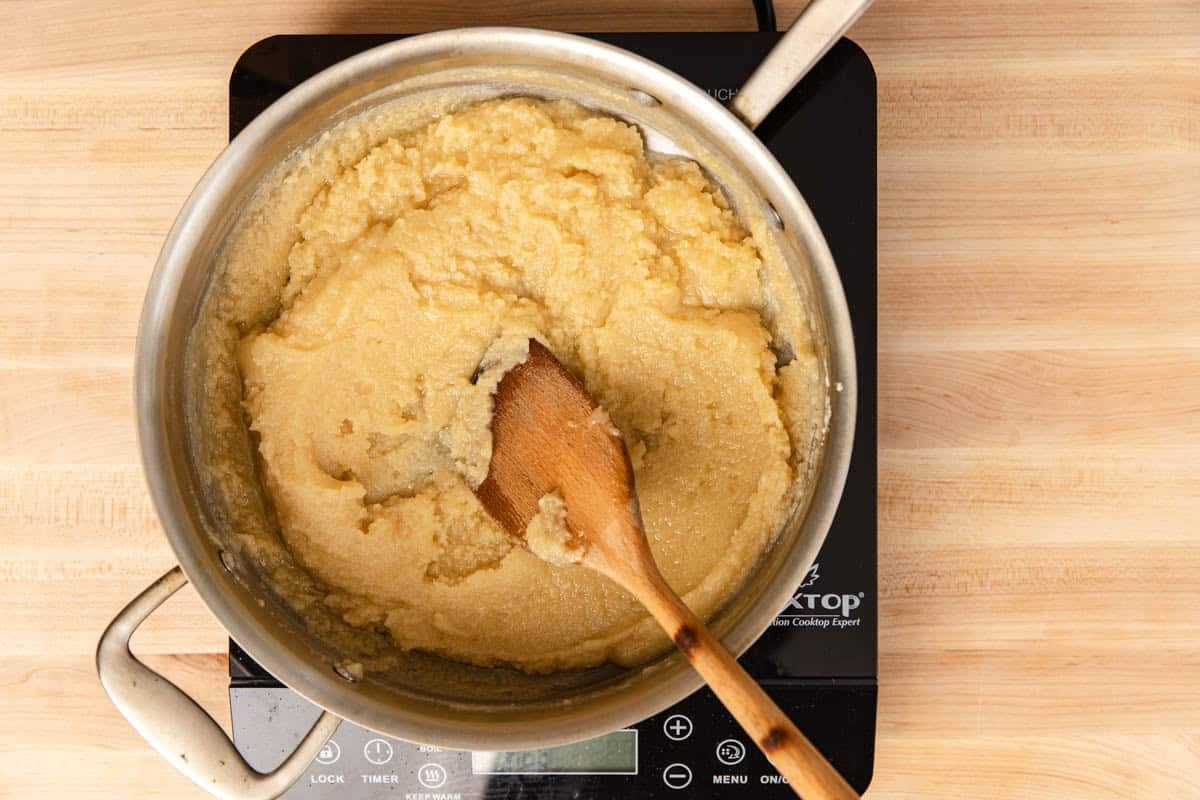 Making a blonde roux in a stainless steel pan with a wooden spoon.