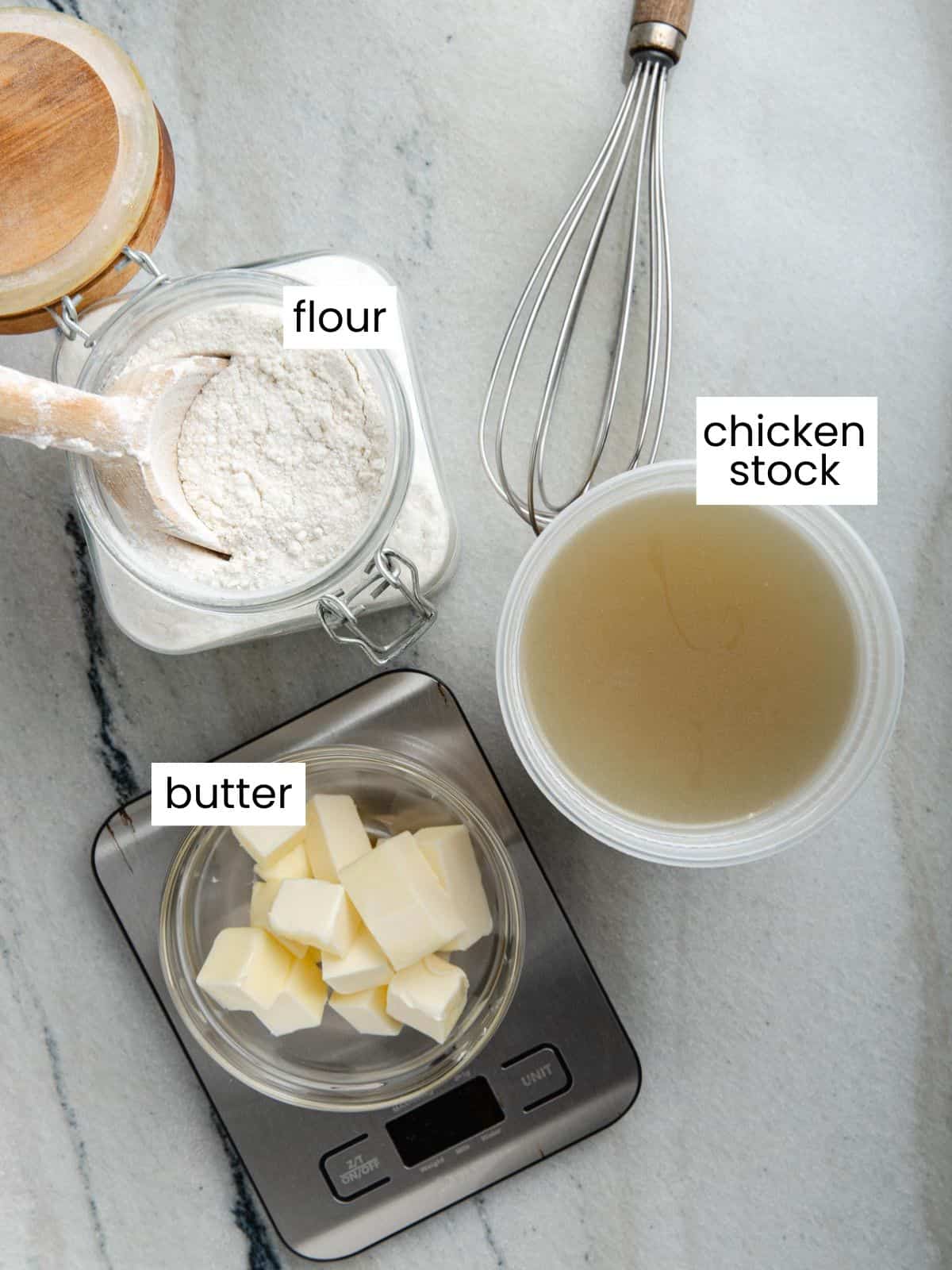 Flour, chicken stock, and cubed butter sitting on a digital scale.