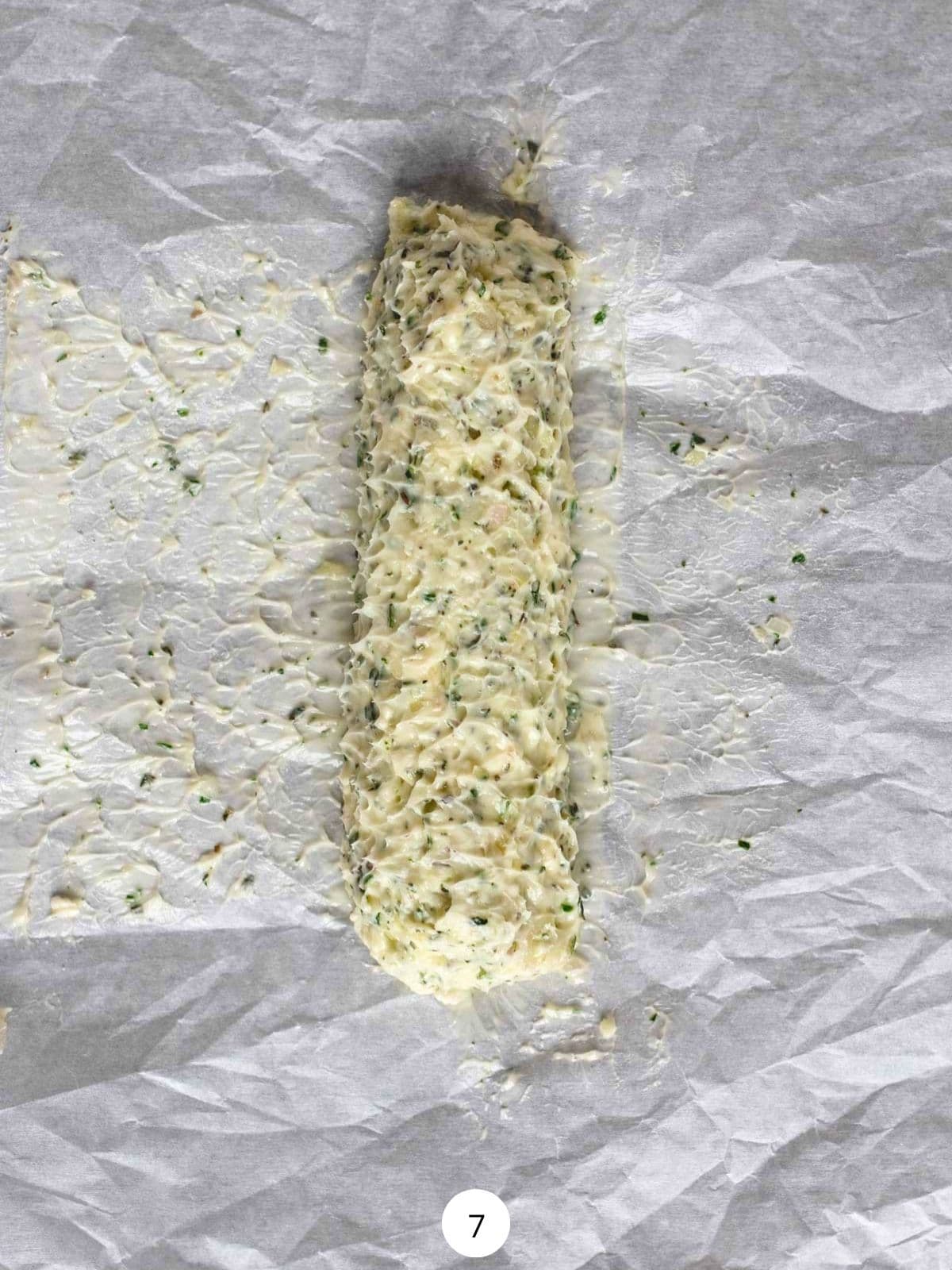 Compound butter rolled into a log on a piece of parchment paper.